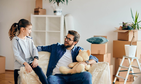 Happy father and daughter talking while relocating into a new apartment.